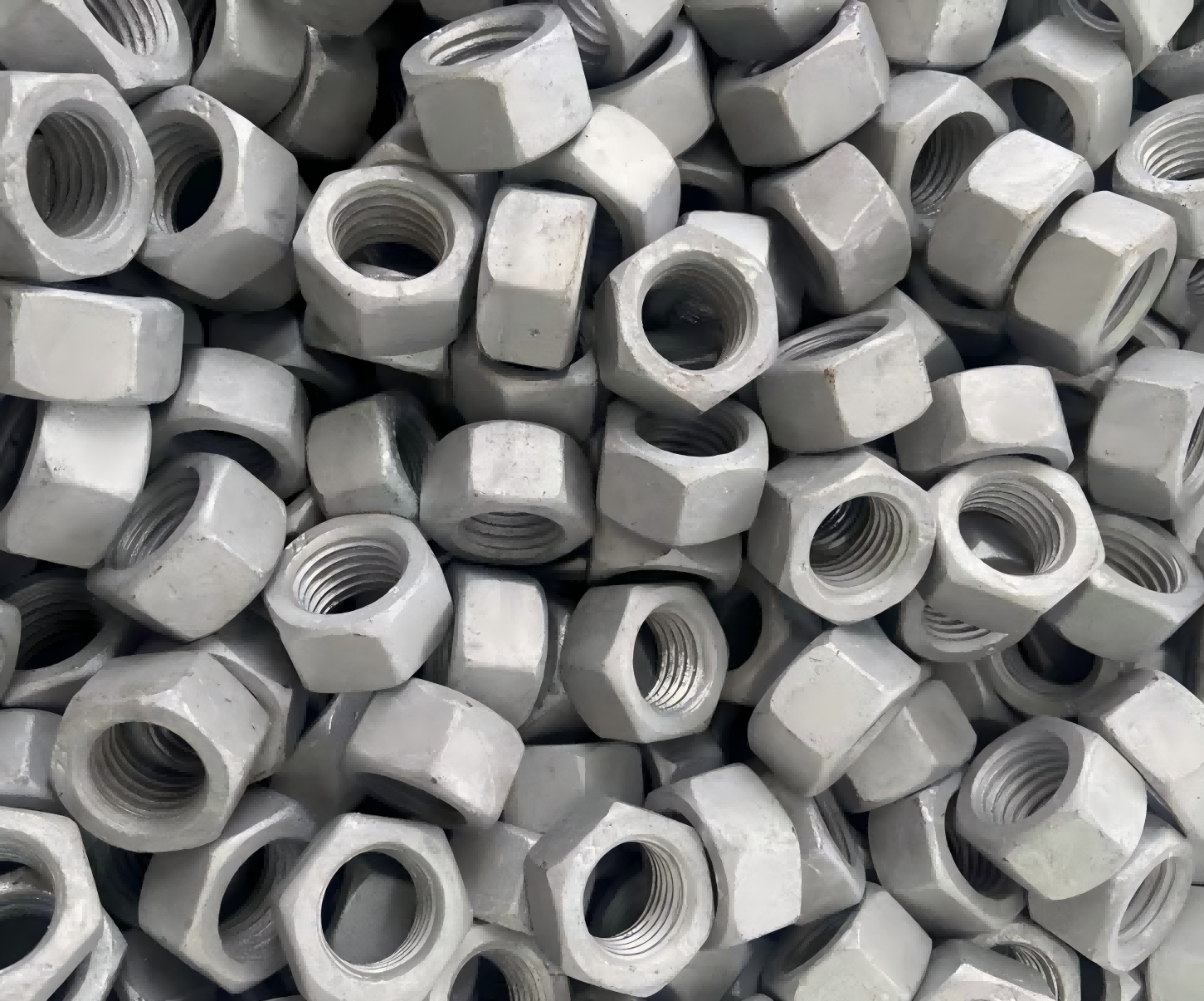 Why is retapping necessary for hot-dip galvanized nuts?